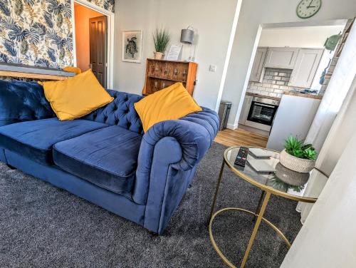 Sofá azul en la sala de estar con mesa en Spacious contemporary apartment en Ramsgate