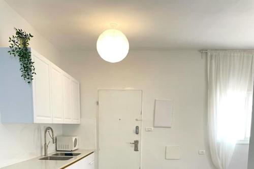 a kitchen with white cabinets and a light fixture at Gep's on Lachish in Beit Shemesh