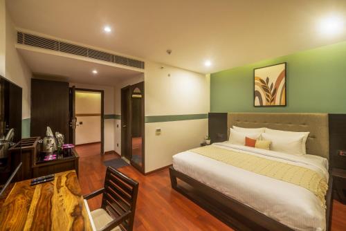 een slaapkamer met een bed en een bureau en een kamer bij Olive MG Road Dunsvirk Inn - by Embassy Group in Bangalore