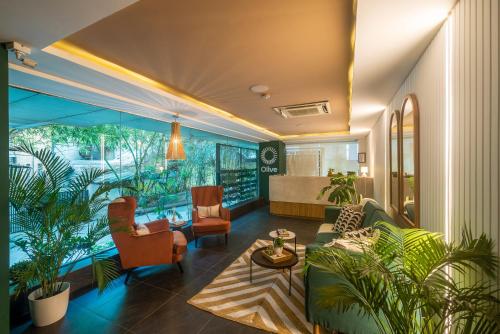 a living room filled with furniture and plants at Olive MG Road Dunsvirk Inn - by Embassy Group in Bangalore