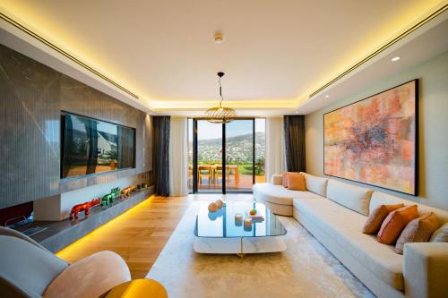 sala de estar con sofá y TV en Mare Deluxe Residences & Villas, en Gundogan