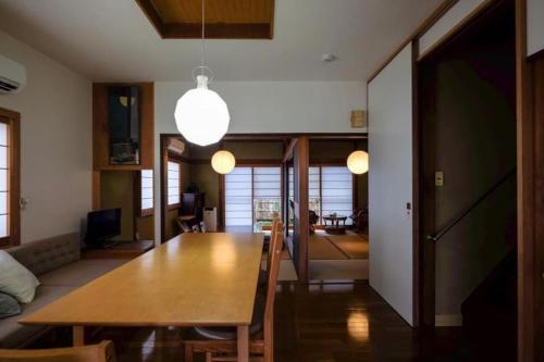 ein Esszimmer und ein Wohnzimmer mit einem Holztisch in der Unterkunft Vacation house月yue in Tokushima