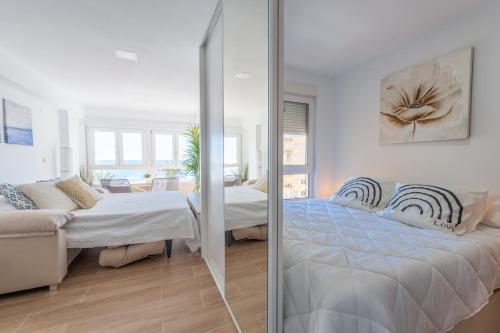 1 dormitorio con 2 camas y pared de cristal en Apartamento Sunset Algarrobo by Solset, en Algarrobo Costa