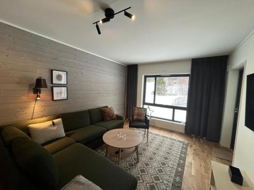 a living room with a couch and a table at Funäs Fjällby Funäsdalen in Funäsdalen