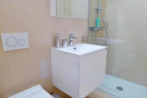 ein Badezimmer mit einem weißen Waschbecken und einer Dusche in der Unterkunft Chesa Auricula - a80609 in Pontresina