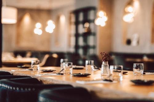 a long wooden table with glasses and a vase of flowers at Hotel Palcát in Tábor