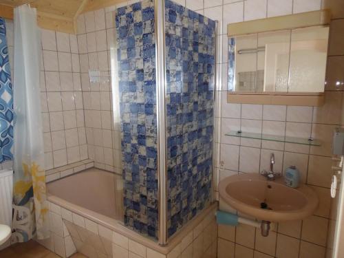 ein Badezimmer mit einer Badewanne und einem Waschbecken in der Unterkunft Ferienwohnung Rumrich in Kurort Altenberg