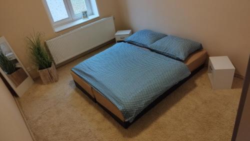 1 cama en una habitación pequeña con 2 mesas en Apartmán v centru Jihlavy, en Jihlava