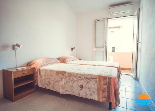 a bedroom with a bed and a table with a lamp at Casa Mameli Apartment Villasimius in Villasimius