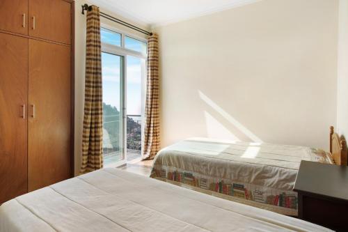 1 dormitorio con 2 camas y ventana grande en Madeira Villa Liliana, en Campanário