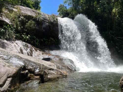 a waterfall on the side of a river at Pousada Boa Vista in Cachoeiras de Macacu