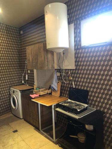 a kitchen with a table and a stove and a microwave at Apartment Zaziashvili 30 in Tbilisi City