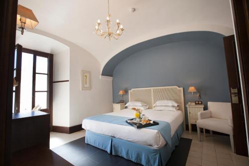 a hotel room with a bed and a chandelier at Hotel Rural OLIVENZA PALACIO in Olivenza