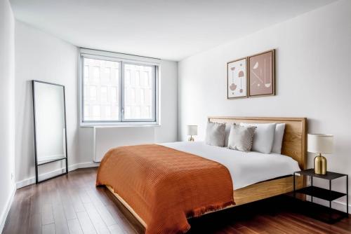 a white bedroom with a large bed and a window at Murray Hill 2br w gym lounge nr East River NYC-944 in New York