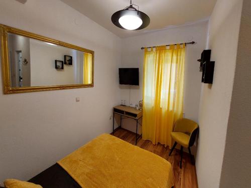 een slaapkamer met een bed, een spiegel en een bureau bij Rooms Argo in Cres