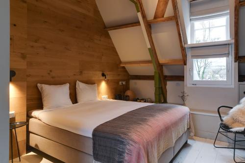 1 dormitorio con 1 cama en una habitación con paredes de madera en Vesting Hotel Naarden en Naarden