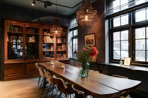 uma sala de jantar com uma mesa de madeira e cadeiras em Vesting Hotel Naarden em Naarden