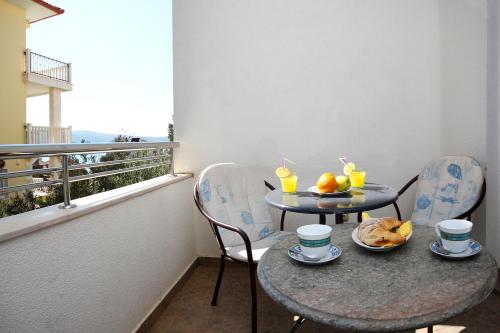 a balcony with two tables and two chairs with drinks at Apartments & Rooms Villa Petra in Zaboric