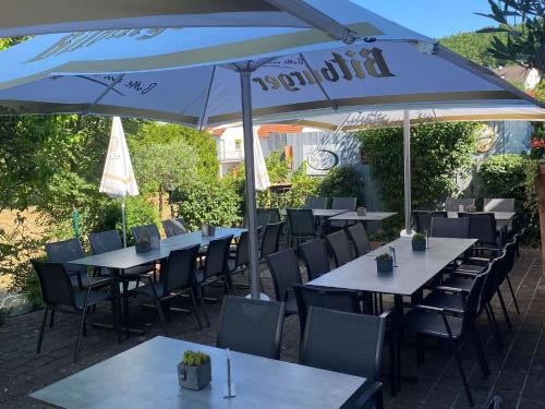Restaurant San Marco في Ammerndorf: مجموعة طاولات وكراسي تحت مظلة