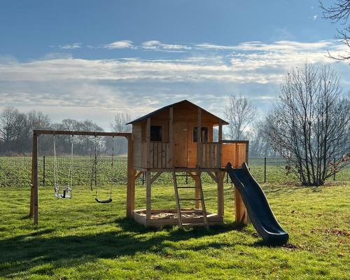 a wooden playground with a slide in a field at Landhofmühle in Eltendorf