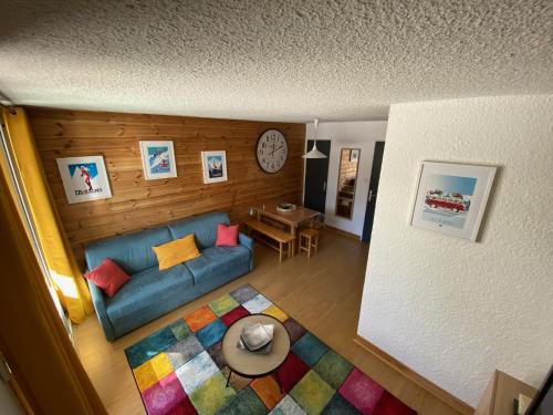a living room with a blue couch and a table at APPARTEMENT RÉNOVE, RÉSIDENCE COTE BRUNE, CENTRE STATION, PIED DES PISTES, 30m² 4/5 pers in Les Deux Alpes