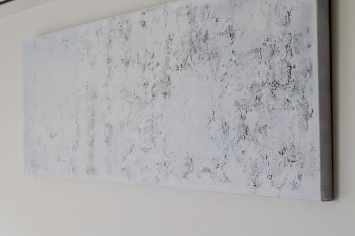 um quadro branco pendurado numa parede em Eucalyptus - The Apartment em Olhos de Água