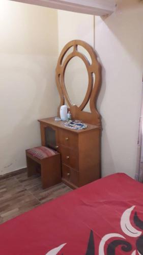 a bedroom with a wooden dresser and a mirror at DAN'S PLACE in Accra