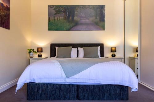 a bedroom with a large bed with a painting on the wall at Tanunda Central Apartment in Tanunda