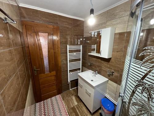 a bathroom with a sink and a toilet and a mirror at Cabana Sânziana in Gîrda de Sus