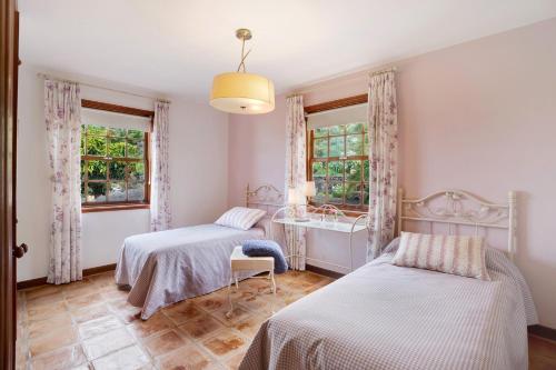 um quarto com 2 camas, um lavatório e janelas em Casa 1700 Los Quemados em Los Quemados