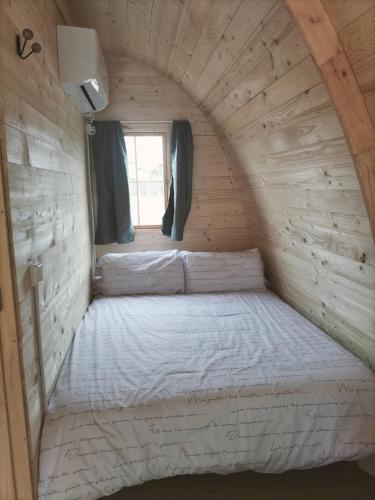 Habitación pequeña con 2 camas en una pared de madera. en LAS CASAS DE DURÓN, en Durón
