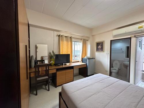 um quarto com uma cama e uma secretária com um computador em 66 Apartment em Ban Khlong Nong Yai