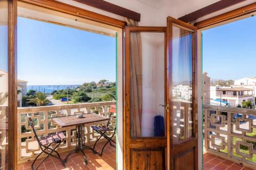a room with a balcony with a table and chairs at Apartamentos Can Salas in Cala Figuera