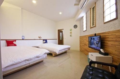 埔里鎮的住宿－Q House ，一间带两张床的卧室和一台电视