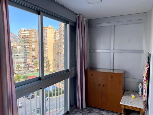 a bedroom with a large window with a view of a city at Halcon Levante in Benidorm