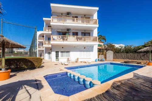 Villa con piscina frente a un edificio en Apartamentos Can Salas, en Cala Figuera