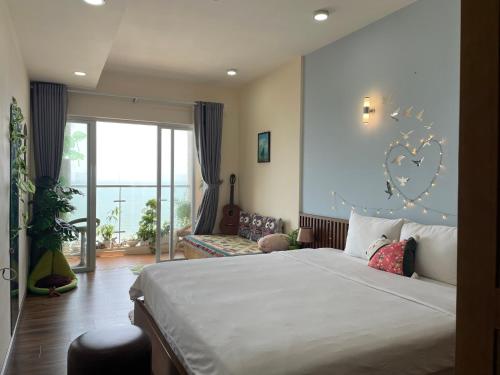 a bedroom with a large bed and a large window at Ocean Eyes - Gold Sea Vung Tau Building in Vung Tau