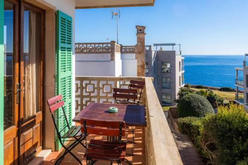 a table and chairs on a balcony with a view of the ocean at Apartamentos Can Salas in Cala Figuera