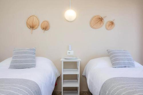 two beds sitting next to each other in a room at Apartamentos Can Salas in Cala Figuera