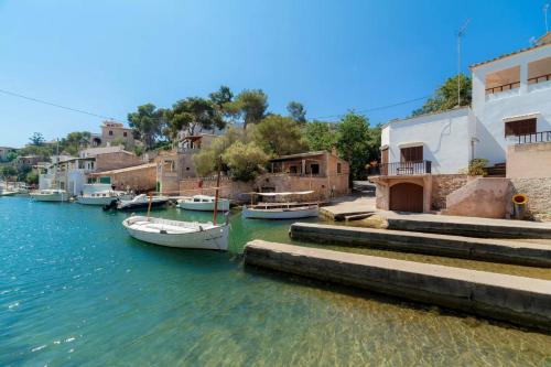 a group of boats docked in the water next to houses at Apartamentos Can Salas in Cala Figuera