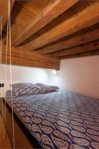 un lit dans une chambre avec un plafond en bois dans l'établissement Appartement lumineux en centre-ville, à Arles