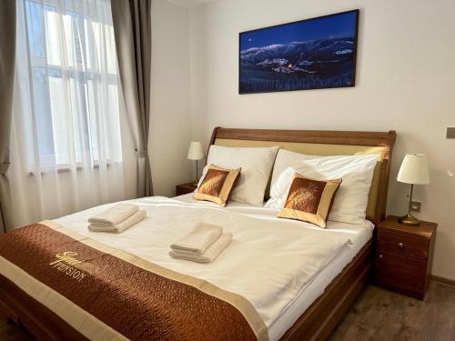 a bedroom with a large bed with two pillows on it at SYNEK Pension in Špindlerův Mlýn