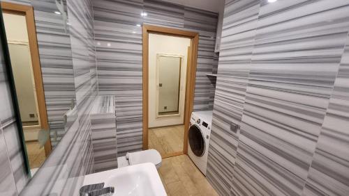 ein Badezimmer mit einem Waschbecken und einer Waschmaschine in der Unterkunft Kalamaja apartment - Kotzebue 33 in Toompea