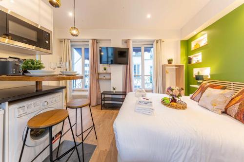 une chambre avec un lit blanc et des murs verts dans l'établissement Cosy Studio - 2P- Beauregard - 3, à Paris