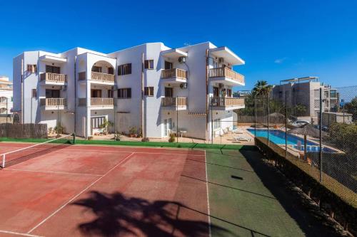 a building with a tennis court in front of it at Apartamentos Can Salas in Cala Figuera
