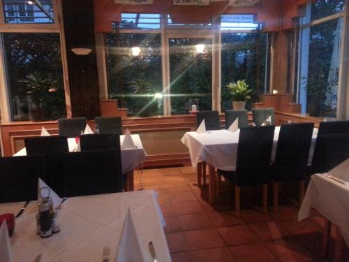 a dining room with a table and chairs and windows at Central Hotel Winnenden in Winnenden