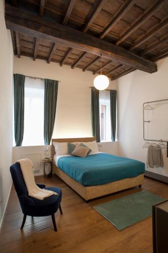 een slaapkamer met een bed en een stoel erin bij Palazzetto de Lante Appartamento Pinta in Rome