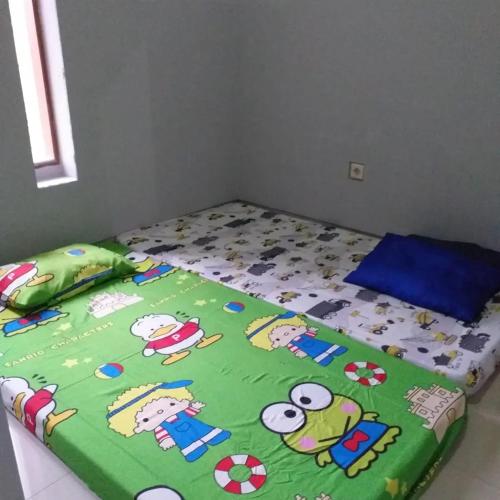 Una cama con dibujos animados en un dormitorio en HOMESTAY SYARIAH GRIYO VIEW SAWAH, en Godean