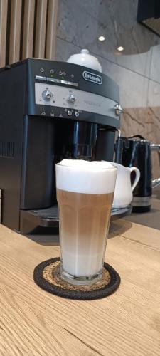 a cup of coffee sitting next to a coffee maker at Apartament Skorpion Marina & Spa Sagaris Dziwnów in Dziwnów