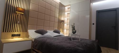 a bedroom with a large bed and a table at Apartament Skorpion Marina & Spa Sagaris Dziwnów in Dziwnów